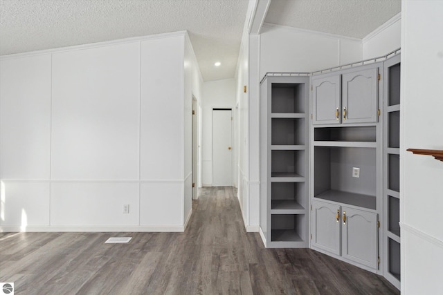 interior space with dark wood-type flooring, built in features, and a textured ceiling