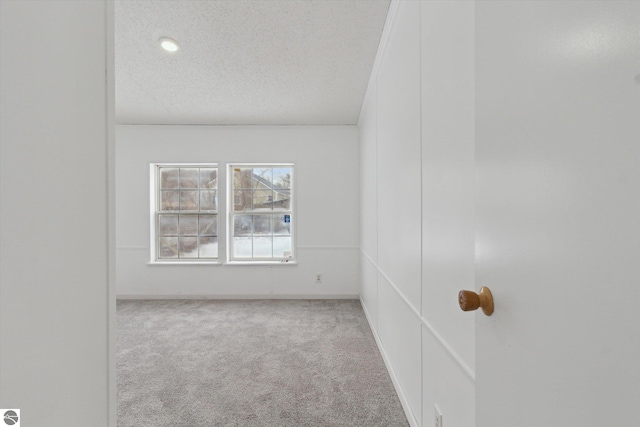 carpeted spare room featuring a textured ceiling