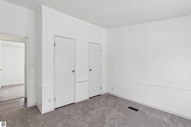 unfurnished bedroom featuring light colored carpet and a textured ceiling