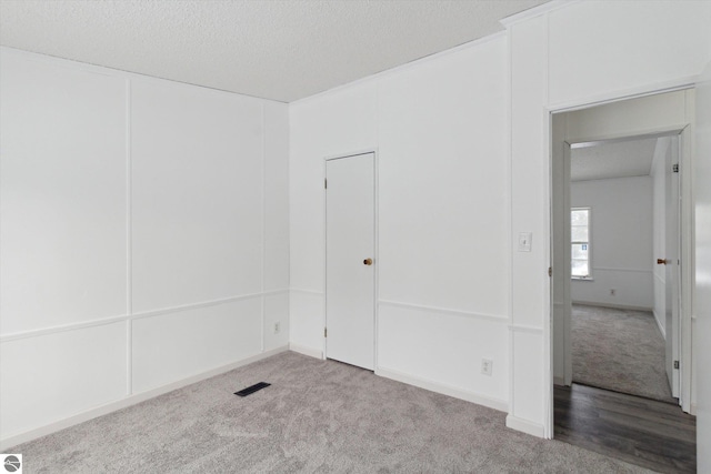 empty room featuring a textured ceiling and carpet