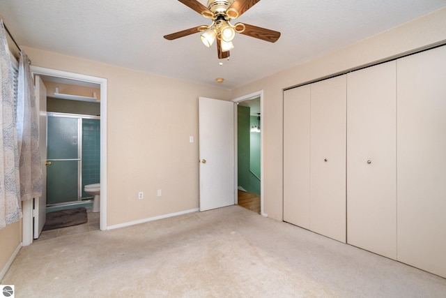 unfurnished bedroom with ceiling fan, light carpet, ensuite bath, and a closet