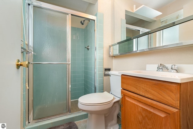 bathroom with vanity, a shower with shower door, and toilet