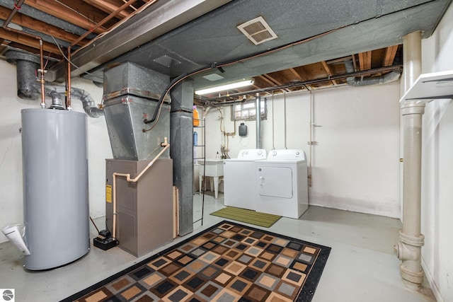 basement with water heater, heating unit, and independent washer and dryer