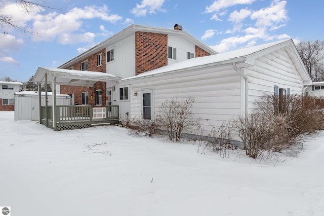 snow covered property with a hot tub