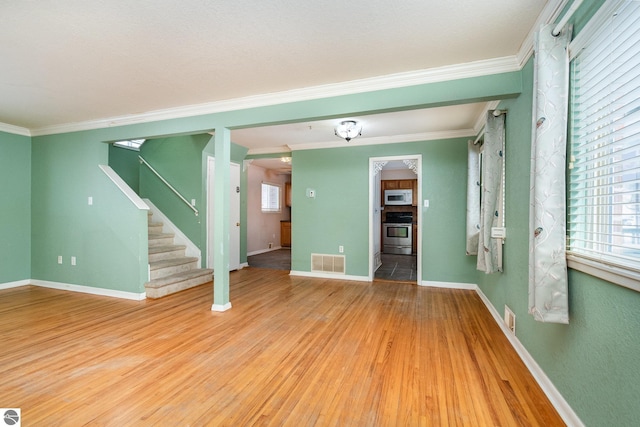 unfurnished room with crown molding and light hardwood / wood-style floors