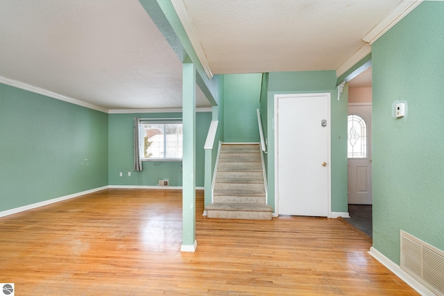 entryway with crown molding and light hardwood / wood-style flooring