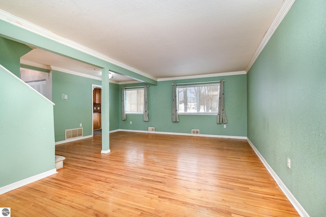 unfurnished living room featuring ornamental molding and light hardwood / wood-style floors