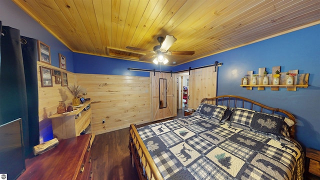 bedroom featuring ornamental molding, a barn door, dark wood-type flooring, and ceiling fan