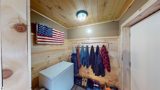 interior space featuring wood ceiling, wooden walls, and ornamental molding