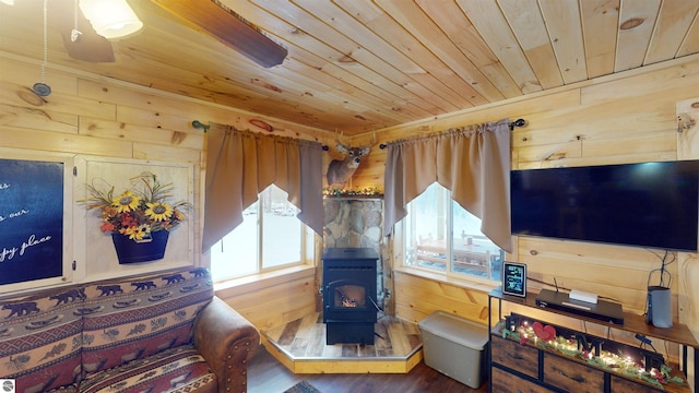 living room featuring a wood stove, hardwood / wood-style floors, wooden ceiling, and wood walls