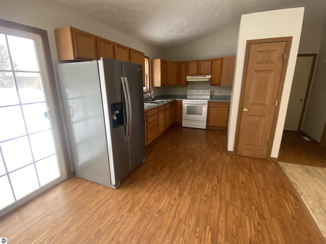 kitchen with sink, white electric range, stainless steel fridge, and light hardwood / wood-style floors