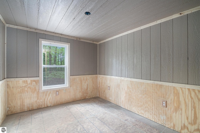 spare room featuring wood ceiling, wooden walls, and ornamental molding