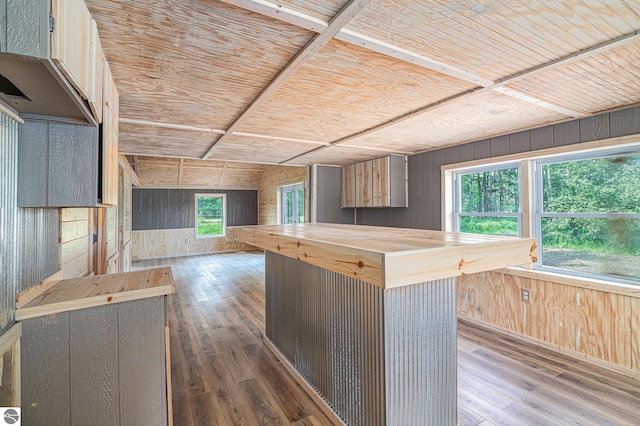 kitchen with dark hardwood / wood-style floors, wood counters, wood walls, a center island, and wooden ceiling