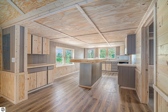 kitchen featuring a kitchen island, light brown cabinetry, wood ceiling, and wood walls