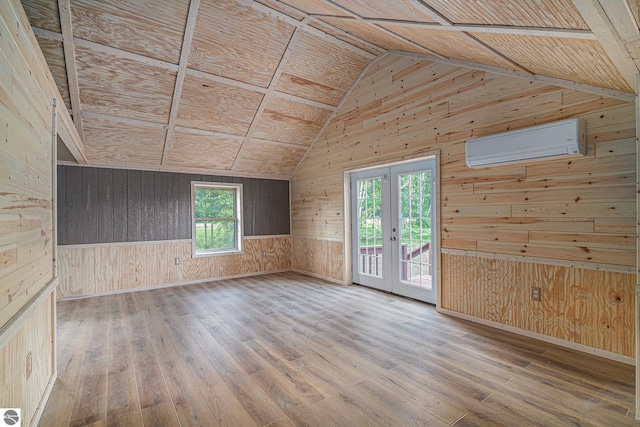 spare room featuring an AC wall unit, plenty of natural light, lofted ceiling, and wood ceiling