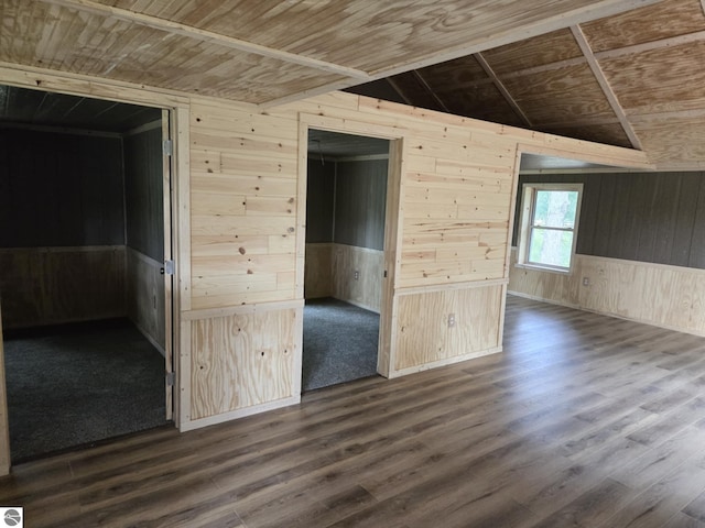 spare room with dark hardwood / wood-style flooring, wooden walls, wooden ceiling, and vaulted ceiling