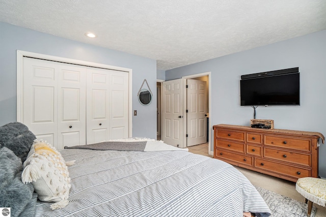 bedroom featuring recessed lighting, a closet, light carpet, and a textured ceiling