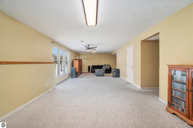 interior space featuring carpet flooring, a ceiling fan, and baseboards