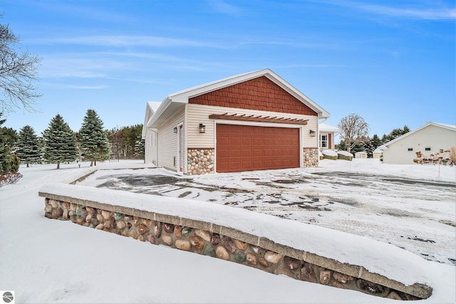 snow covered property with stone siding