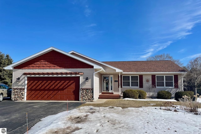 view of front facade with aphalt driveway, stone siding, an attached garage, and a shingled roof