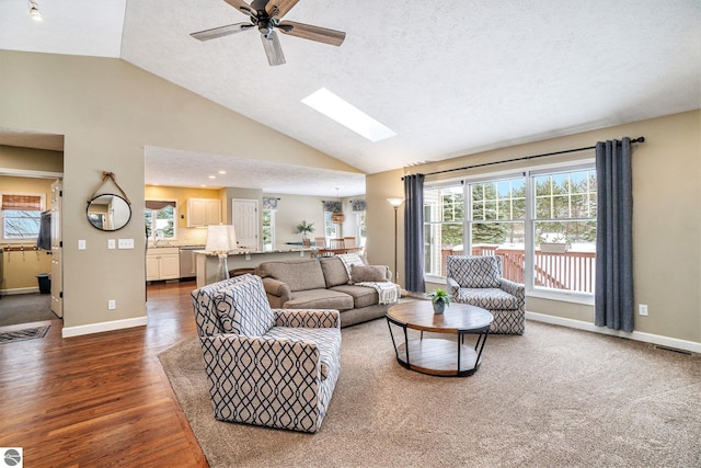 living area featuring visible vents, a skylight, baseboards, and dark wood-style flooring