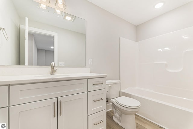 full bathroom with toilet, wood-type flooring, shower / washtub combination, and vanity