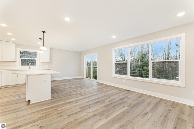 unfurnished living room featuring sink and light wood-type flooring