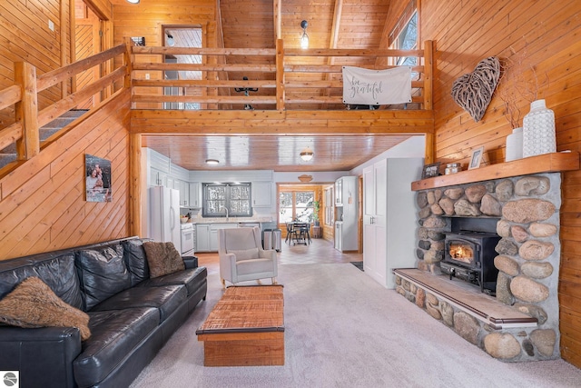 living room with wood ceiling, a towering ceiling, wood walls, and carpet flooring