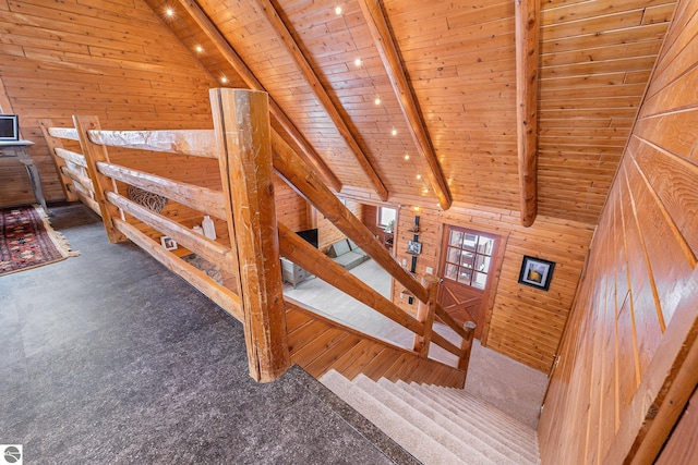 staircase with vaulted ceiling with beams, wood ceiling, and wood walls