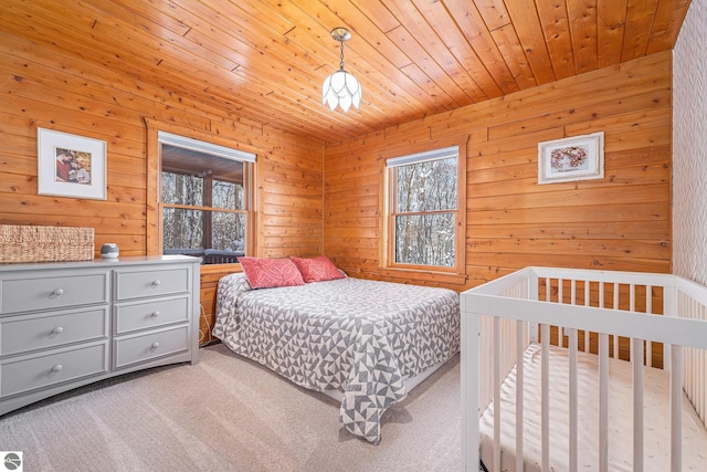 carpeted bedroom featuring wooden ceiling and wood walls