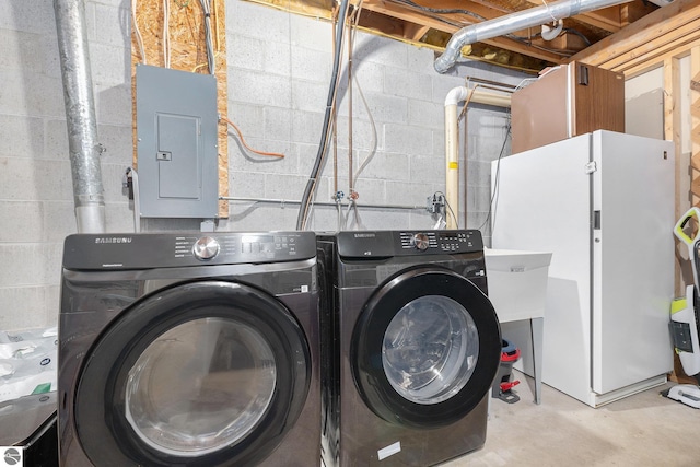 washroom with washing machine and clothes dryer and electric panel