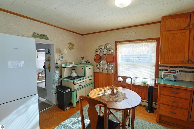 dining room featuring a baseboard radiator, ornamental molding, and light hardwood / wood-style floors