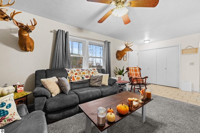 living room with light tile patterned floors, a textured ceiling, and ceiling fan