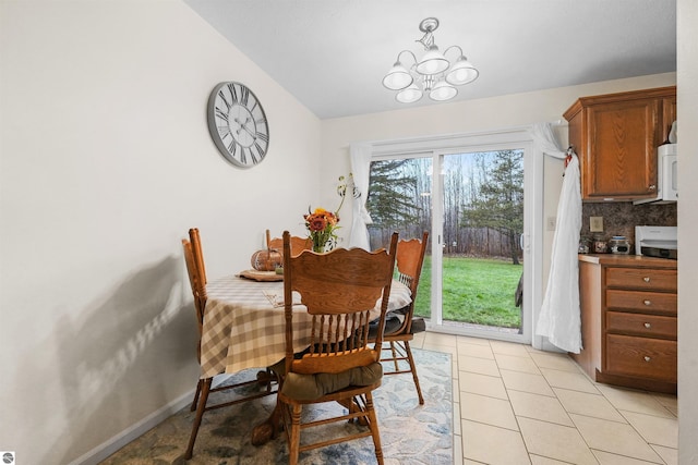 dining area with light tile patterned flooring and a notable chandelier