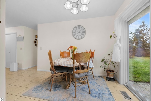 tiled dining area with an inviting chandelier and plenty of natural light