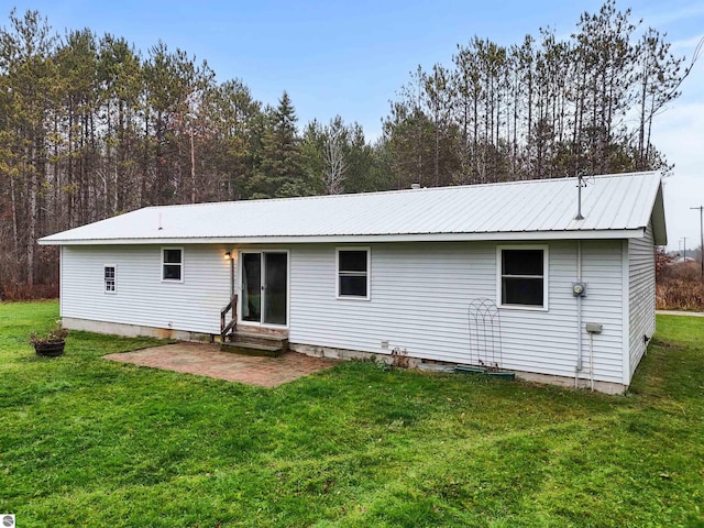 back of property with a yard and a patio area