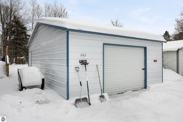 snow covered structure featuring a garage
