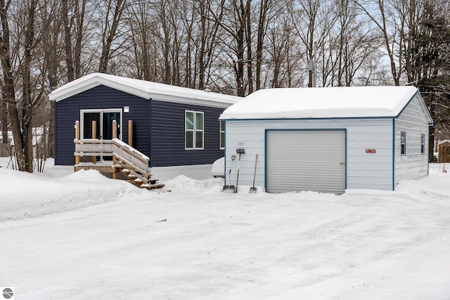 view of front of property with a garage and an outdoor structure