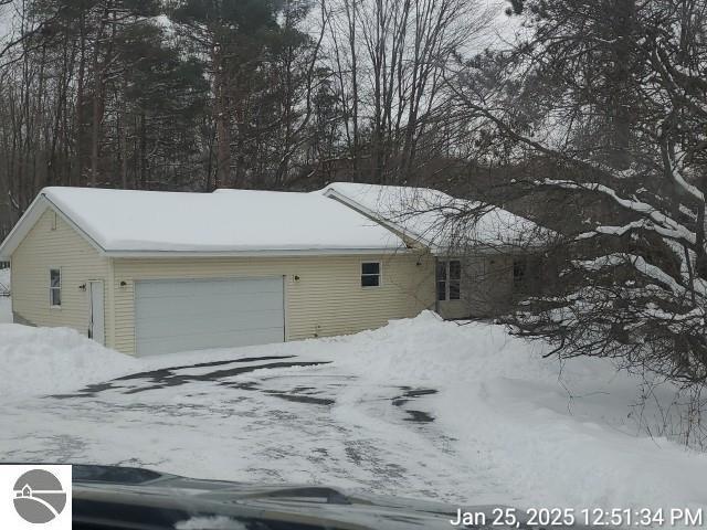 snow covered property featuring a garage