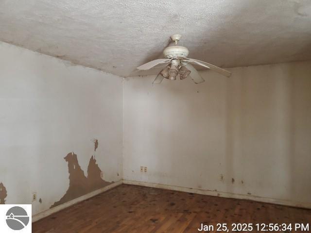 spare room with wood-type flooring, a textured ceiling, and ceiling fan