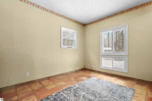 empty room featuring light tile patterned flooring and a textured ceiling