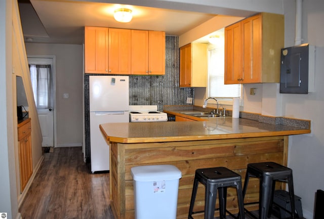 kitchen featuring sink, a kitchen breakfast bar, electric panel, white refrigerator, and kitchen peninsula