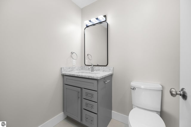 bathroom featuring vanity, tile patterned floors, and toilet