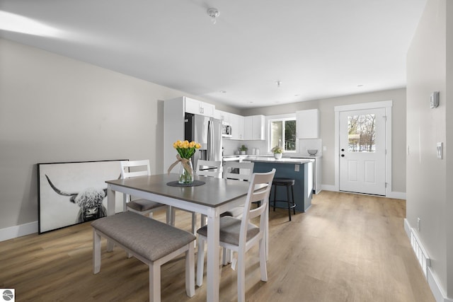 dining space with light hardwood / wood-style floors