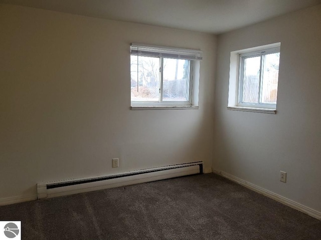 carpeted spare room with a wealth of natural light and baseboard heating