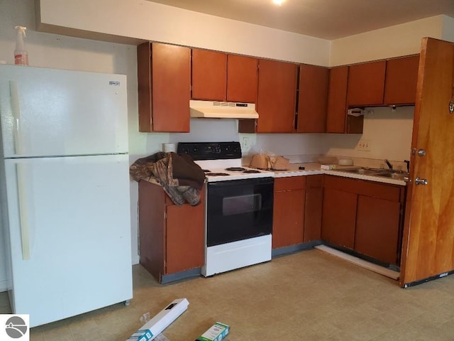 kitchen featuring sink, white fridge, and electric range oven