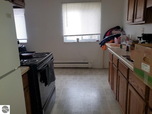 kitchen featuring black electric range oven, a baseboard radiator, and white fridge