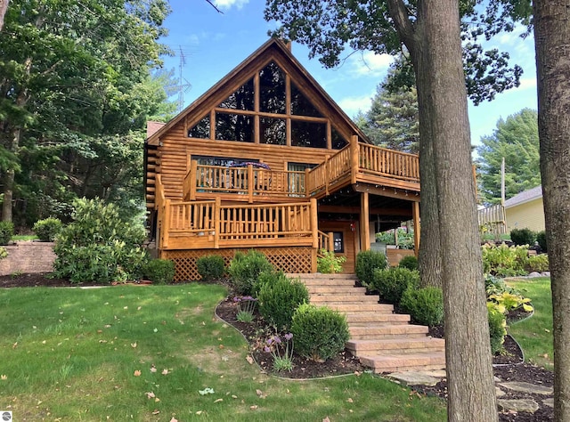 rear view of house with a wooden deck and a lawn