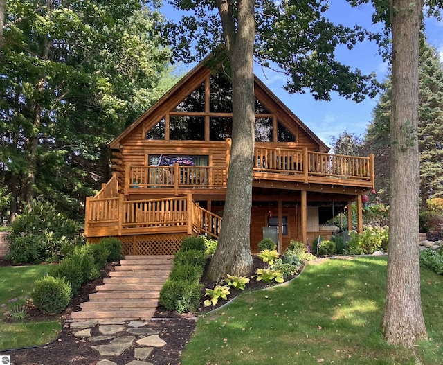 rear view of property featuring a yard and a deck