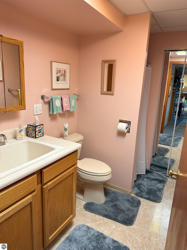 bathroom with vanity, a paneled ceiling, and toilet